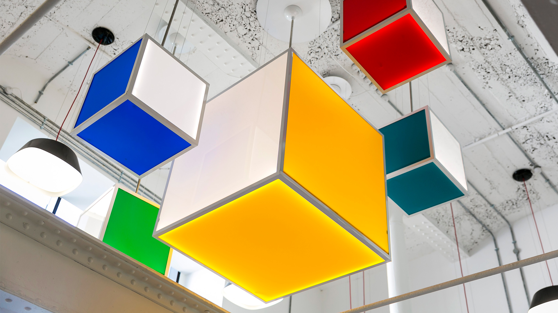 Bright lighting cubes in shades of yellow, red, green and blue hang from the ceiling of the Grainstore lobby