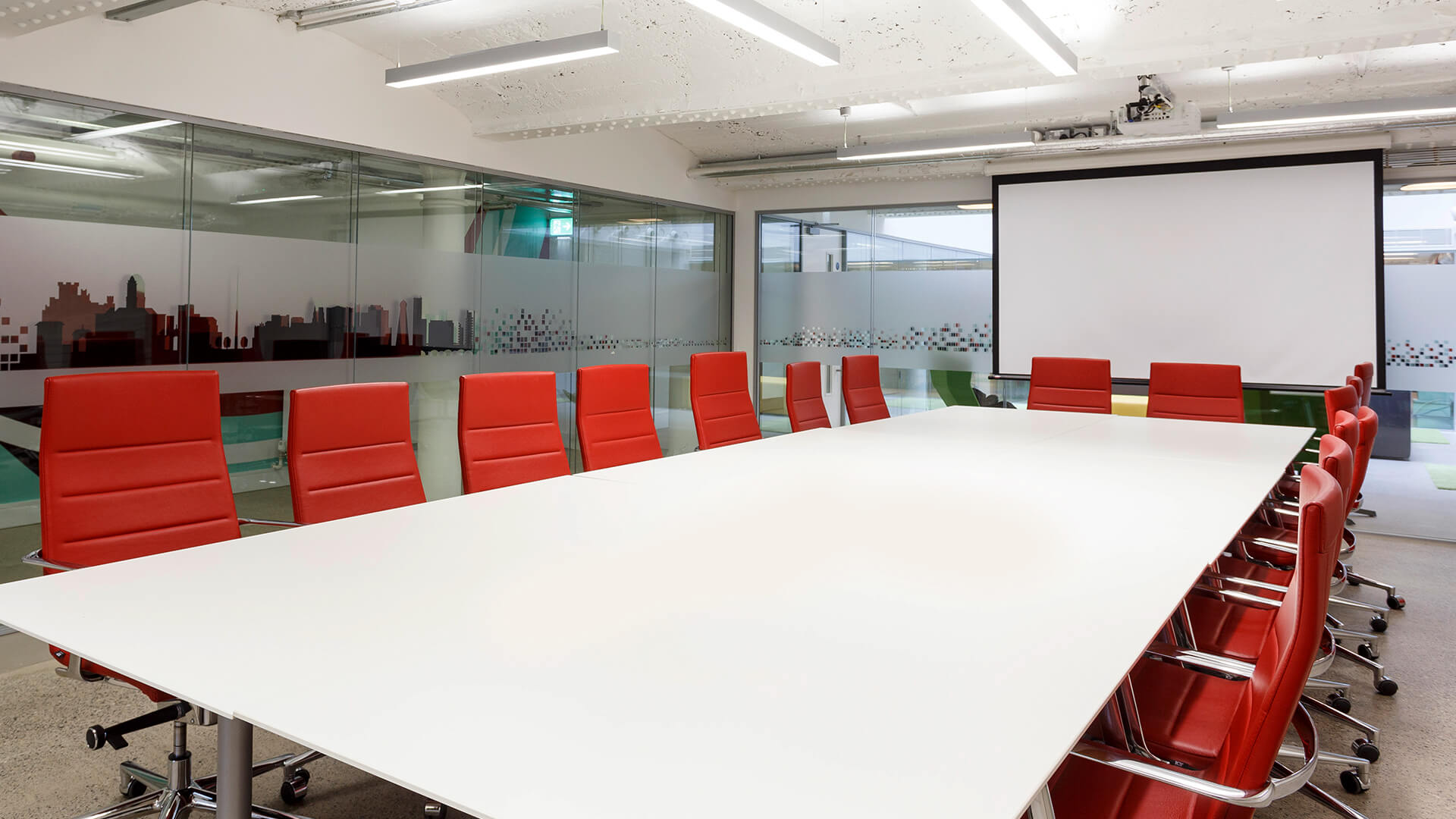 A close up of the Marshalsea meeting room table with a projector screen in the background