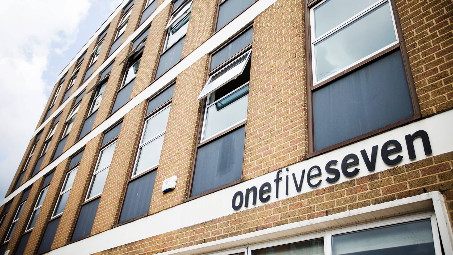 The exterior frontage of the building with a sign displaying 'onefiveseven' in raised black letters