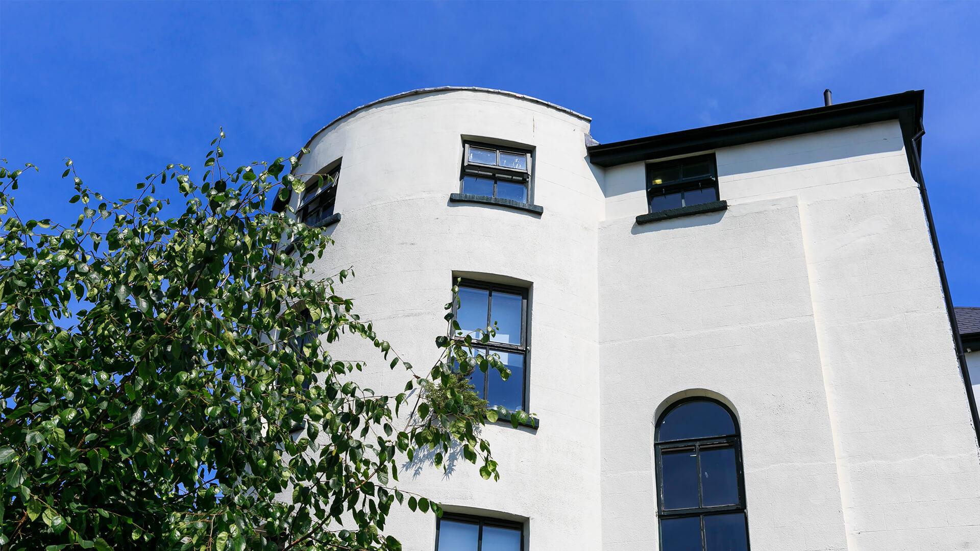 The white rendered exterior of Townhouse Twenty2 with its distinctive curve and large windows
