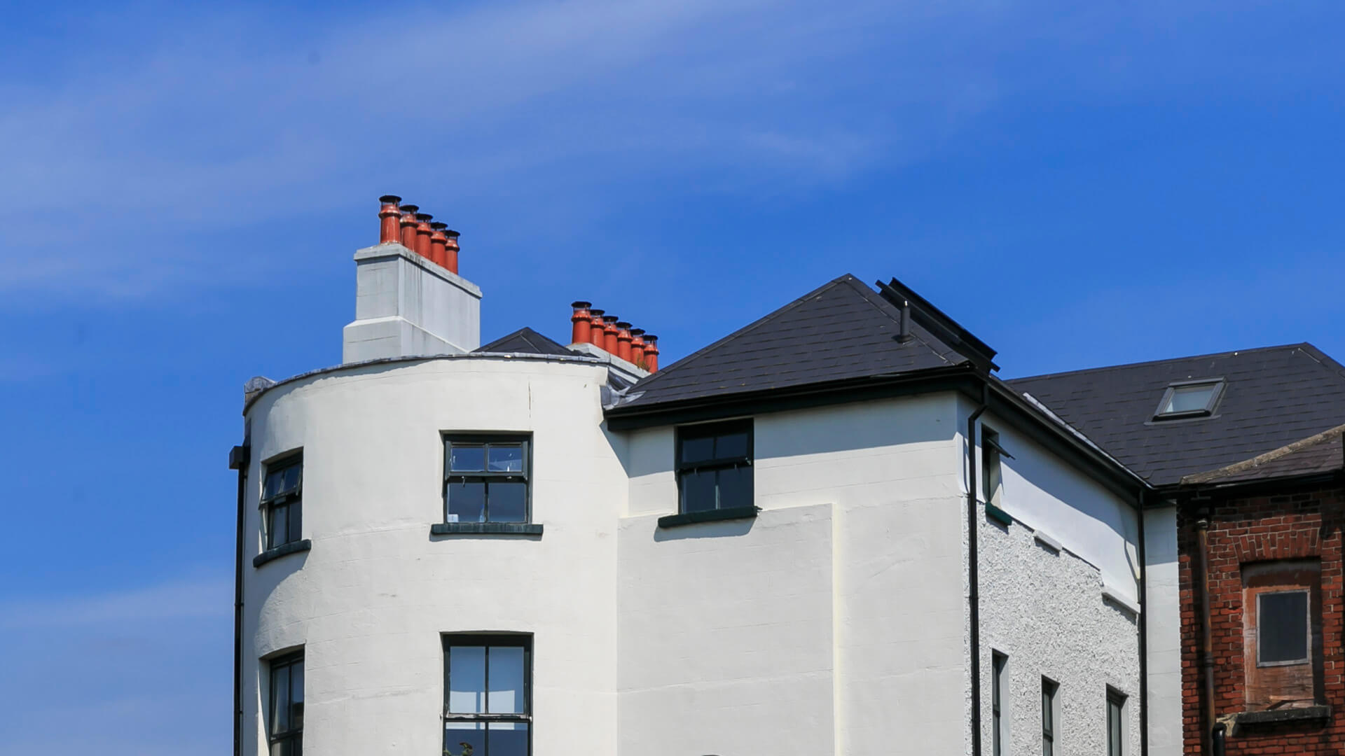 The upper portion of the Townhouse Twenty2 exterior showing orange chimney stacks against a blue sky